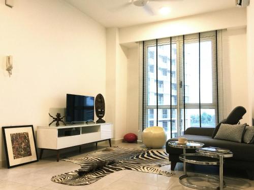 a living room with a couch and a tv at Afiniti Residences in Johor Bahru