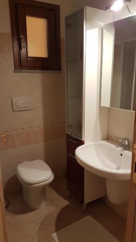 a bathroom with a white toilet and a sink at Residenza Lentisco in Castelsardo