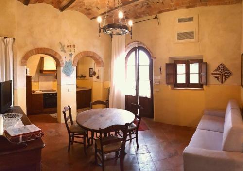a living room with a table and a couch at Podere Cunina in Buonconvento