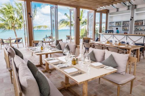 a restaurant with tables and chairs with the ocean in the background at Celes Samui in Bophut