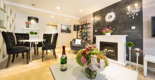 a living room with a fireplace and a table and chairs at Luxuslodge Wernigerode in Wernigerode
