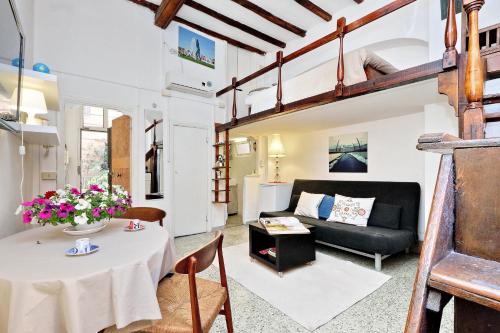 a living room with a table and a couch at Pretty Flat Trastevere in Rome