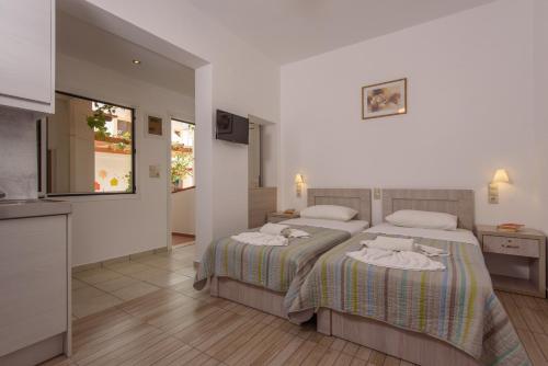 a bedroom with two beds with towels on them at Nikos Hotel in Matala