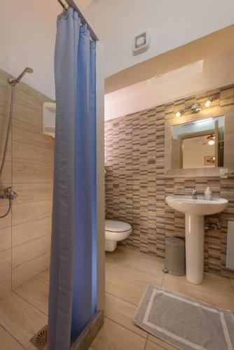 a bathroom with a shower and a toilet and a sink at Nikos Hotel in Matala