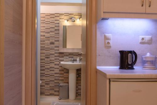 a small bathroom with a sink and a mirror at Nikos Hotel in Matala