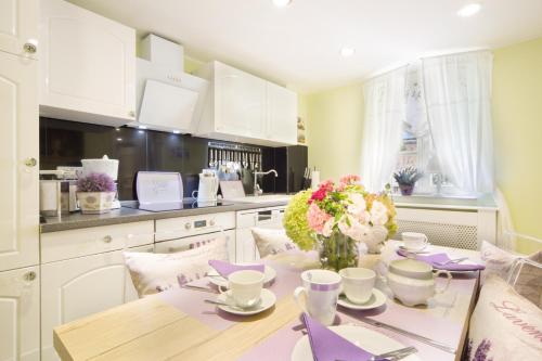 a kitchen with a table with a vase of flowers on it at Luxuslodge Wernigerode in Wernigerode