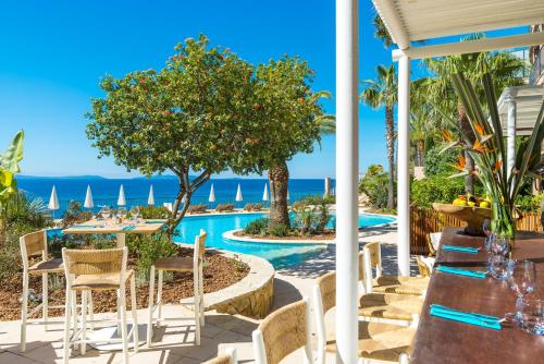 a view of the ocean from the patio of a resort at Hôtel Le Bailli De Suffren in Rayol-Canadel-sur-Mer