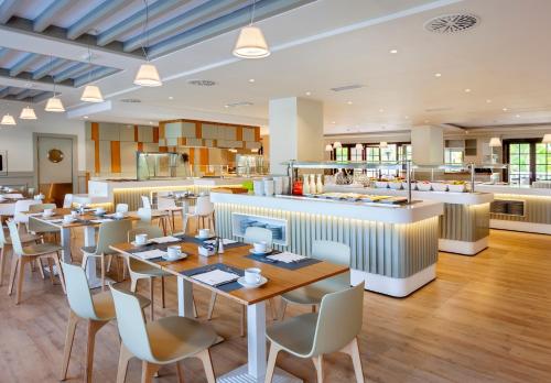 a restaurant with tables and chairs and a counter at Barceló Marbella in Marbella
