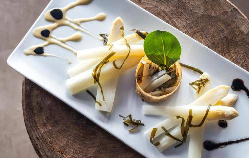 a white plate with food on a table at Hôtel Le Bailli De Suffren in Rayol-Canadel-sur-Mer