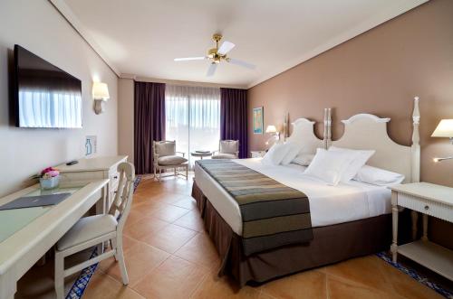 a hotel room with a large bed and a desk at Barceló Marbella in Marbella