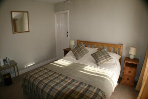 a bedroom with a bed and two lamps and a mirror at The Old Forge in Wilton