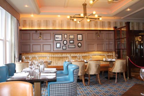 a restaurant with tables and chairs and a chandelier at Abbey Hotel Donegal in Donegal