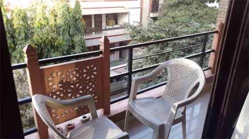two chairs sitting on a balcony with a view at Grace Home in New Delhi
