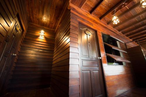 a wooden hallway with a door and a staircase at Khuang Chang Kam in Nan