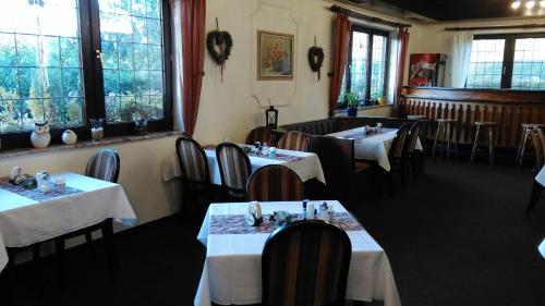 a dining room with tables and chairs and windows at Landhaus im kühlen Grunde Garni in Pracht