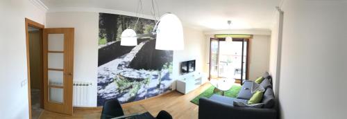 a living room with a large painting on the wall at High Rentxacobeo in Sarria