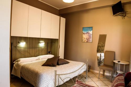 1 dormitorio con 1 cama, armario y silla en Sotto Il Vulcano en Nicolosi