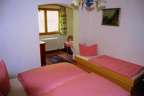 two beds in a room with red and white sheets at Pension Wassererhof in Gerlos