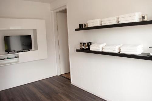 a room with white towels and a tv on a wall at Byonz in Groningen