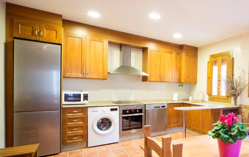 a kitchen with wooden cabinets and a washer and dryer at Casa Rural Francisca in Requena