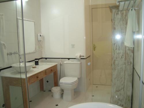 a bathroom with a toilet and a sink and a shower at Don Quixote Pousada in Tiradentes
