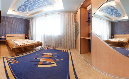 オムスクにあるOmsk Sutki Apartments on 70 let oktyabrya 16/4のベッド2台と鏡が備わる客室です。