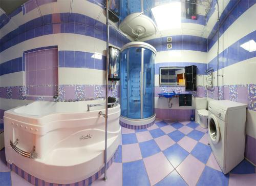 オムスクにあるOmsk Sutki Apartments on 70 let oktyabrya 16/4の紫と青のタイル張りの壁のバスルーム
