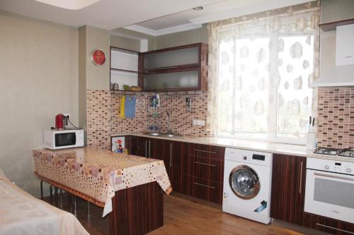 a kitchen with a table and a washing machine at Apartment near the Black Sea Ureki in Ureki
