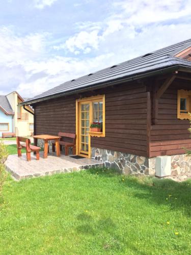 a log cabin with a table and a bench at Tatralandia-Liptov Chatky in Liptovský Mikuláš