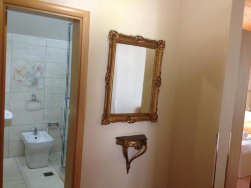 a bathroom with a mirror and a toilet at Hotel Lungomare in Vlorë