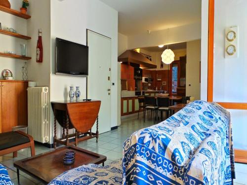 uma sala de estar com um sofá, uma mesa e uma televisão em Baisi Flexyrent em Rapallo