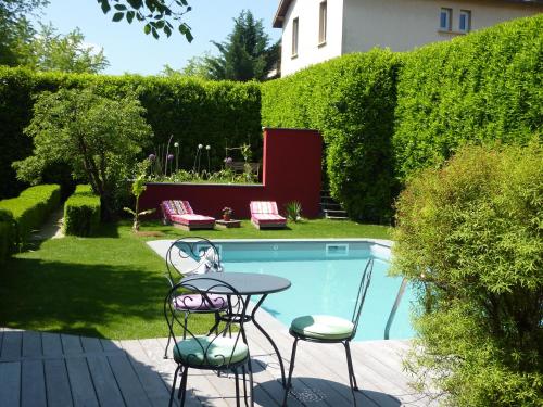 un patio avec une table et des chaises à côté d'une piscine dans l'établissement Chambre d'Hotes 