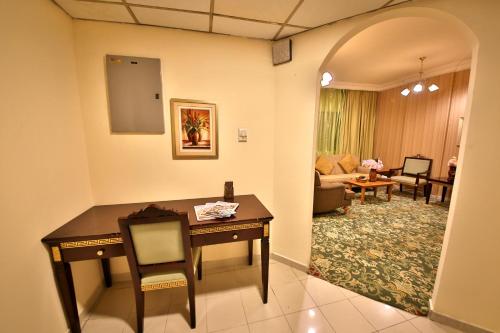 a room with a desk and a living room at Midtown Furnished Apartments in Ajman 
