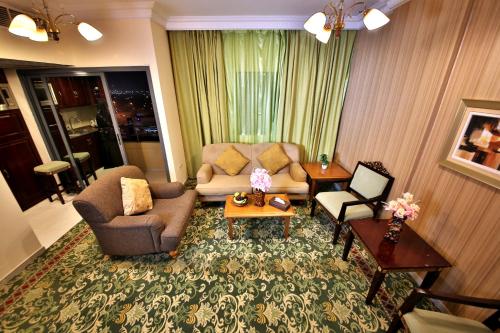 a living room with a couch and a table at Midtown Furnished Apartments in Ajman 