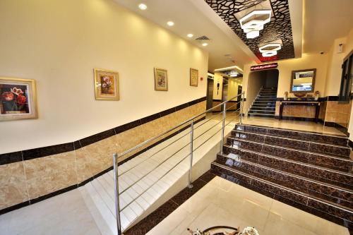 a lobby with stairs in a building at Midtown Furnished Apartments in Ajman 