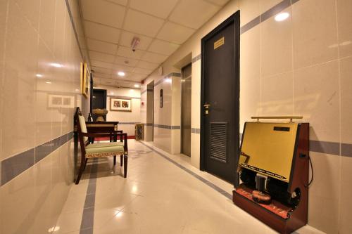 a hallway with a door and a chair and a fish tank at Midtown Furnished Apartments in Ajman 