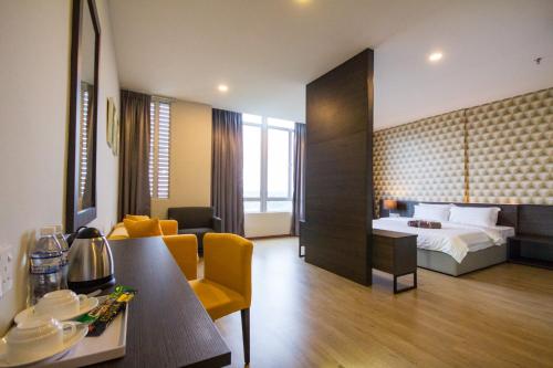 um quarto de hotel com uma cama e uma sala de estar em OMG Hotel em Simpang Ampat