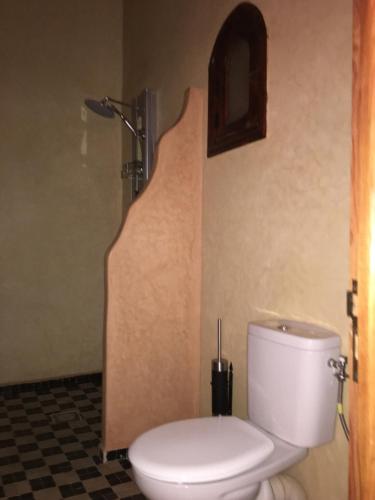a bathroom with a white toilet and a shower at Riad Moha in Merzouga