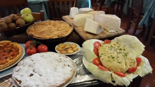a table topped with different types of cheese and pies at Albergo Santo Spirito in Molini di Triora