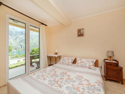 sypialnia z łóżkiem i dużym oknem w obiekcie Apartments Željko w Kotorze