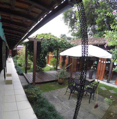 a patio with a table and an umbrella at Pousada Caúca in Abraão
