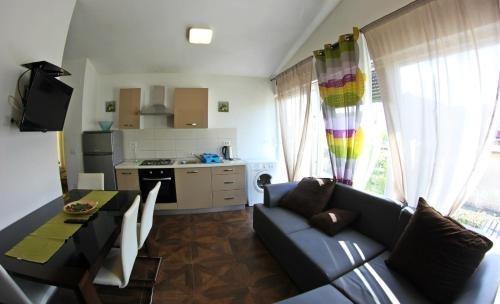 ein Wohnzimmer mit einem Sofa und einem Tisch sowie eine Küche in der Unterkunft Apartments Neno in Umag