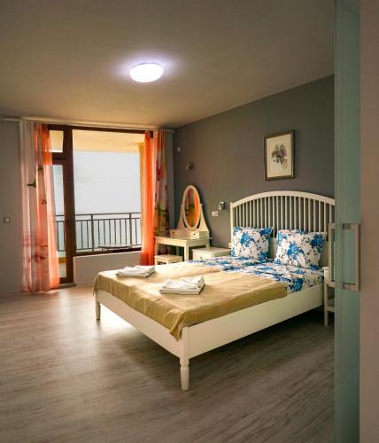 a bedroom with a bed and a balcony at Studios Grace - Port Tsarevo in Tsarevo