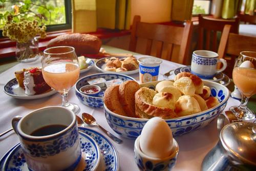 a table topped with plates of food and cups of coffee at Estalagem Tronador in Camanducaia