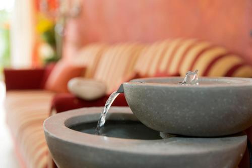 a bathroom sink with water pouring out of it at Hotel Garni Pölzl in Deutschlandsberg
