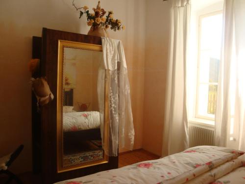 a mirror in a room with a bed and a window at Romantik-Villa LebensART in Reichenfels