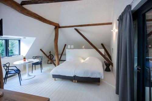 a bedroom with a bed and a table and chairs at Uitgerust voor Zaken in Heerenveen