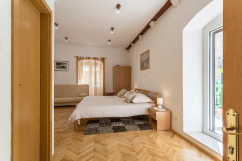 um quarto com uma cama e uma grande janela em Carrara Accommodation em Split