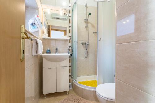 uma casa de banho com um chuveiro, um WC e um lavatório. em Carrara Accommodation em Split
