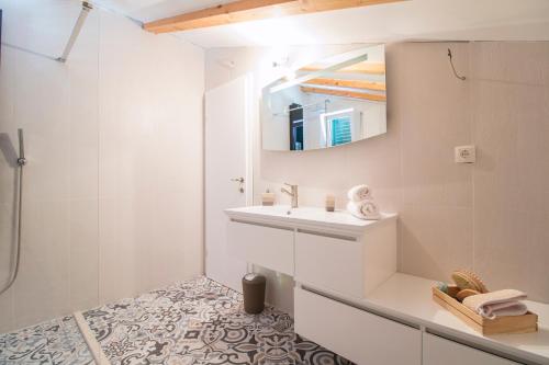 a white bathroom with a sink and a mirror at Villa Kristina in Sevid